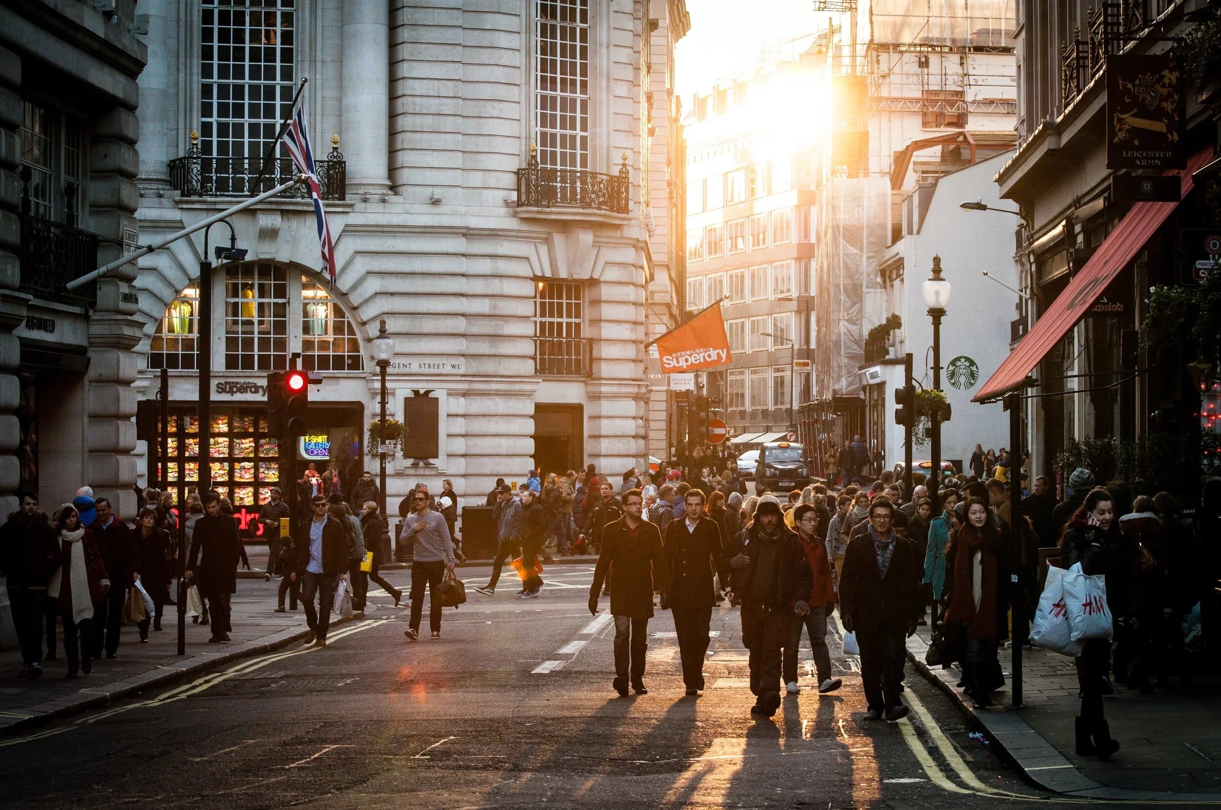 Shoppers on a busy London high street at sunset