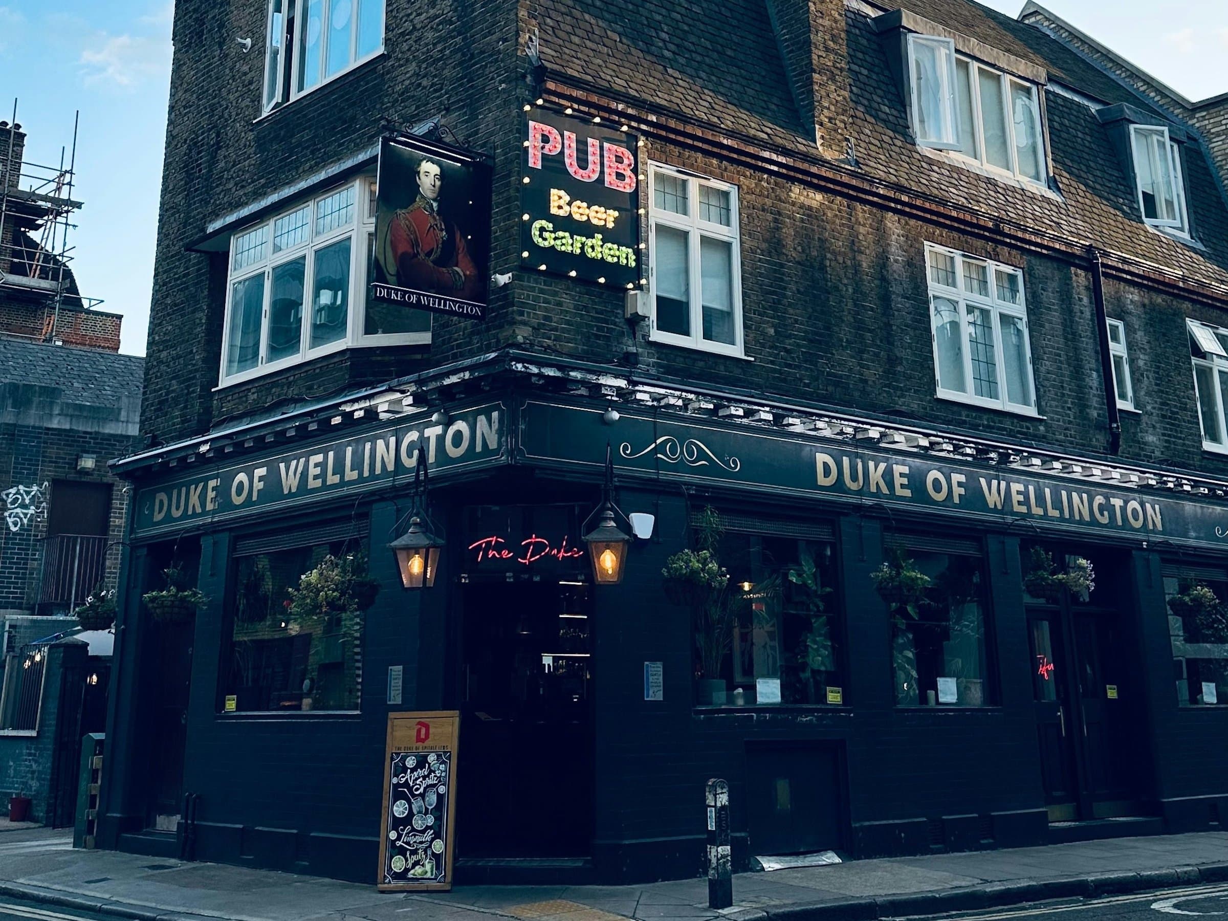 A traditional London corner pub with flower boxes and hanging baskets.