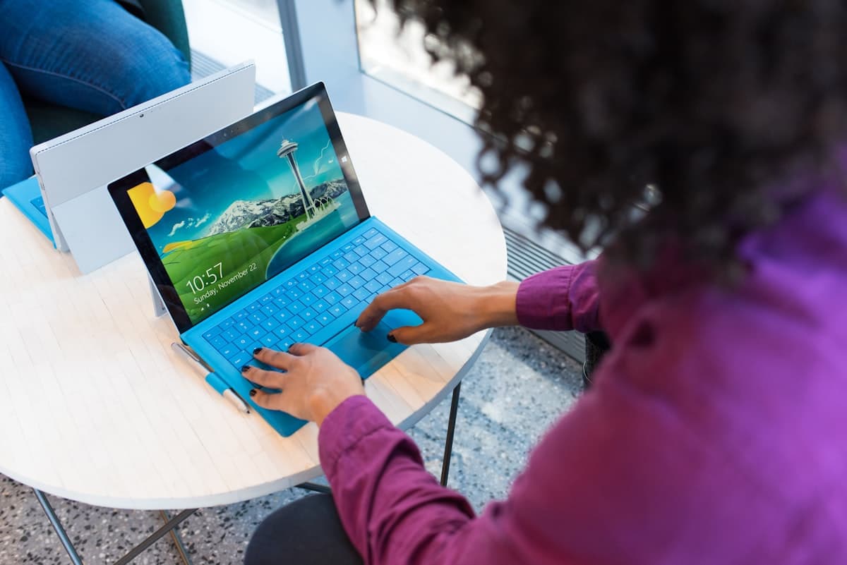 A boardroom presentation screen with a person taking notes on a laptop