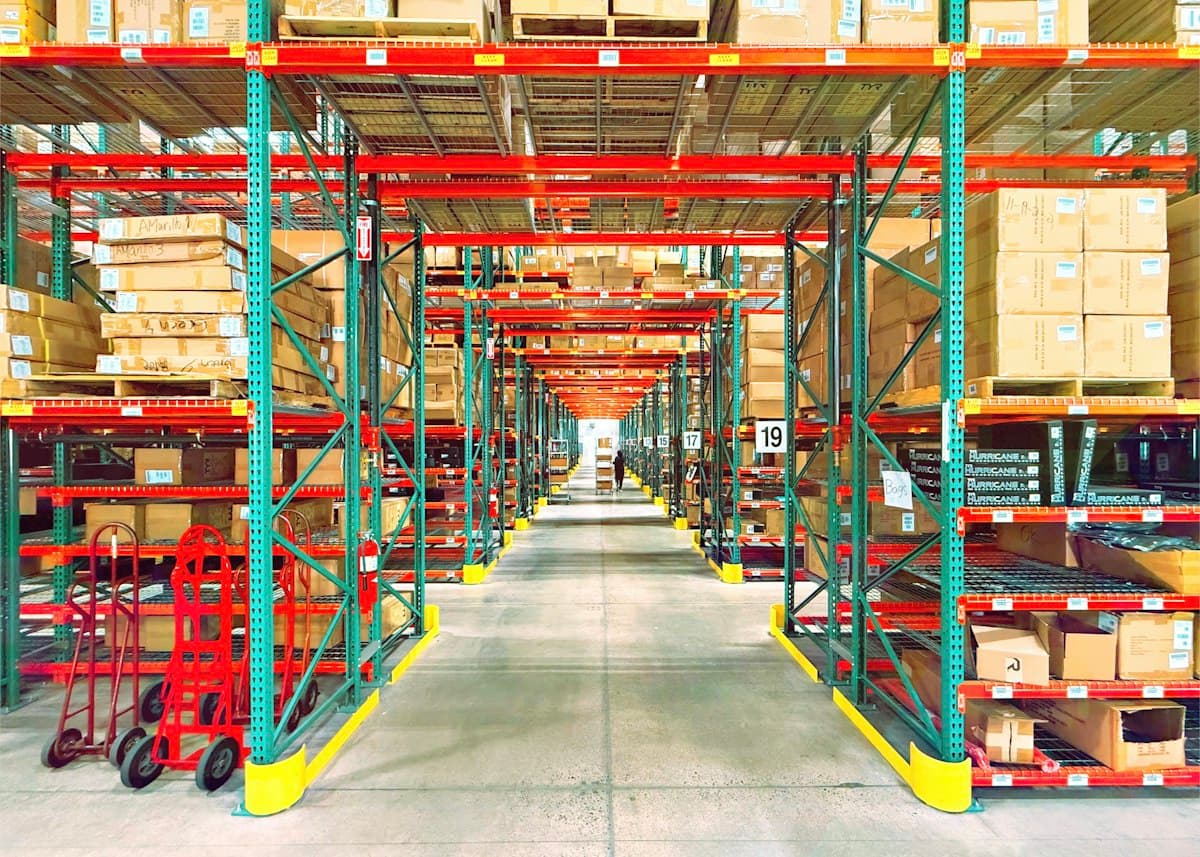 Rows of warehouse shelving stacked with boxes and pallets